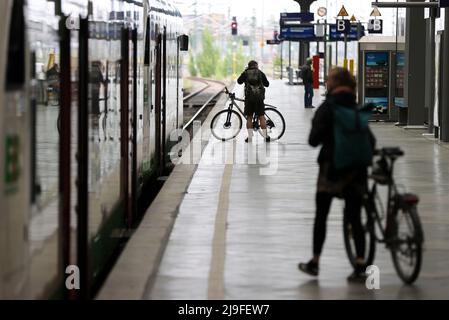 Lipsia, Germania. 23rd maggio 2022. Due viaggiatori salgono a bordo di un treno con le loro biciclette alla Stazione Centrale di Lipsia. La gente in Sassonia potrà acquistare il biglietto da 9 euro per i mezzi pubblici a partire da lunedì. Il biglietto è di solito disponibile presso distributori automatici, punti vendita o autisti di autobus e sarà valido in tutta la nazione a partire da giugno 1. Credit: Jan Woitas/dpa/Alamy Live News Foto Stock