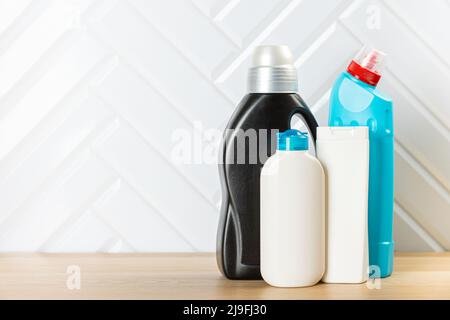 Bottiglie per la pulizia di diverse superfici in cucina, bagno e altre stanze. Primo piano. Vista dall'alto. Striscione largo. Spazio vuoto per il testo o il logo. Foto Stock