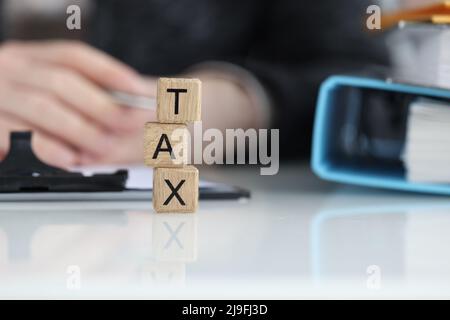 Testo delle imposte sui cubi di legno e sui pagamenti delle tasse e sul concetto di credito Foto Stock