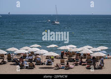 Barcellona, Spagna. 22nd maggio 2022. Sulla spiaggia di Somorrostro si trova un gruppo di ombrelloni bianchi. Barcellona ha raggiunto un record storico di temperatura per il mese di maggio. I termometri toccarono 30 gradi Celsius, incoraggiando residenti e turisti a proteggersi dal sole o andare in spiaggia per rinfrescarsi. Credit: SOPA Images Limited/Alamy Live News Foto Stock