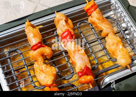 Brocetta di pollo marinata sulla griglia di un barbecue elettrico Foto Stock
