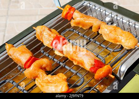 Brocetta di pollo marinata sulla griglia di un barbecue elettrico Foto Stock