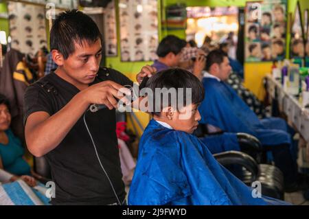 Ragazzo guatemalteco che ottiene un taglio di capelli ad un barbiere, Antigua, Guatemala, America Centrale. © Kraig Lieb Foto Stock