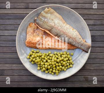 Appetitosi filetti di trote al forno con piselli verdi Foto Stock