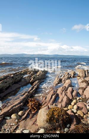 Spiaggia di ciottoli e piccoli affioramenti rocciosi di Machrie Bay che si affaccia su Kilbrannan Sound Isle di Arran North Ayrshire Scozia Foto Stock