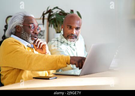 Padre e figlio utilizzando laptop Foto Stock