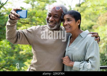 Coppia sorridente che prende selfie con smartphone Foto Stock