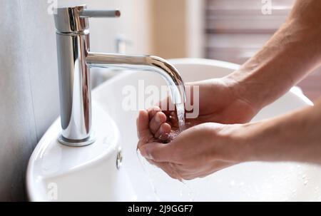 Primo piano dell'uomo che lava le mani sotto l'acqua Foto Stock