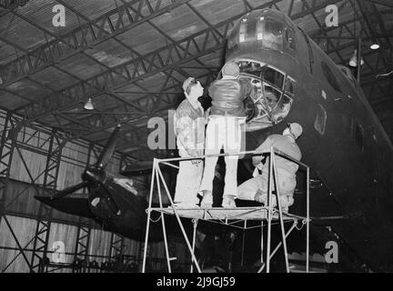 Foto d'epoca circa 1943 dell'equipaggio americano di terra che lavora su un bombardiere britannico Royal Air Force Handley Page Halifax durante la seconda guerra mondiale come parte della cooperazione tra le forze britanniche e statunitensi in Gran Bretagna Foto Stock