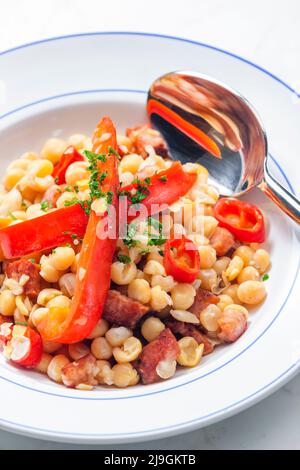 miscela di piselli gialli e pancetta servita con pepe rosso e peperoncino Foto Stock