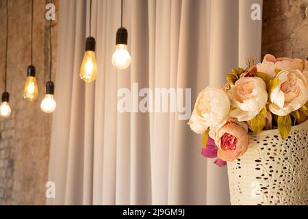 bouquet con fiori vicino alle lampade sulla parete in stile retrò per lo sfondo, decor nell'appartamento, sfondo interno Foto Stock