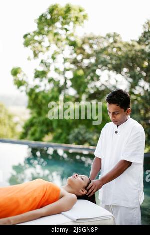 La donna riceve un massaggio al cuoio capelluto all'aperto all'Heritance Kandalama Hotel, Dambulla, Sri Lanka. Foto Stock