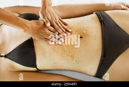 Giovane donna asiatica che riceve scrub corpo a Kayumanis Spa, Kayumanis Ubud, Bali, Indonesia. Foto Stock