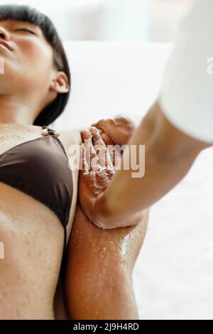Giovane donna asiatica che riceve scrub corpo a Kayumanis Spa, Kayumanis Ubud, Bali, Indonesia. Foto Stock