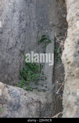 Pozzo di scavo. Vecchia conduttura dell'acqua. Riparazione del tubo dell'acqua e riparazione di una rottura della rete fognaria Foto Stock