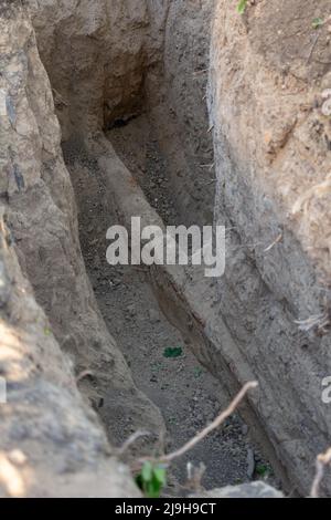 Pozzo di scavo. Vecchia conduttura dell'acqua. Riparazione del tubo dell'acqua e riparazione di una rottura della rete fognaria Foto Stock