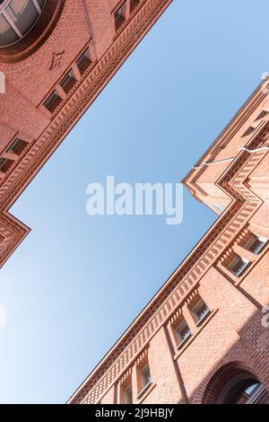 Due case in mattoni modernizzate affacciate l'una all'altra con il cielo blu Foto Stock