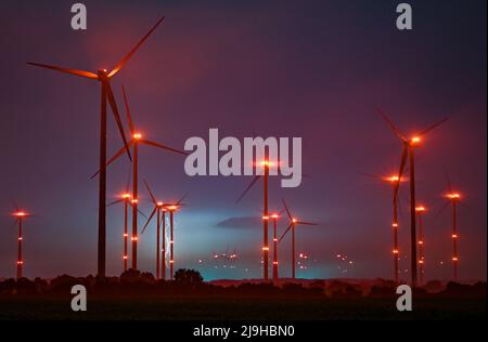 Jacobsdorf, Germania. 20th maggio 2022. Le luci di posizione rosse sulle turbine eoliche illuminano il cielo notturno, mentre i fulmini di una tempesta di tuoni possono essere visti dietro di loro. Credit: Patrick Pleul/dpa/Alamy Live News Foto Stock