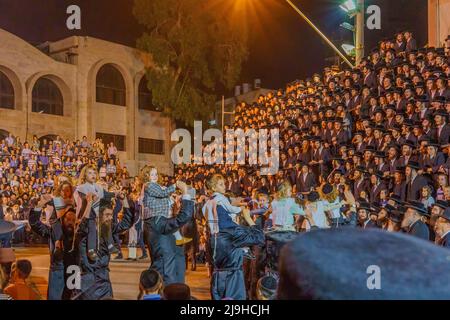 Haifa, Israele - 18 maggio 2022: Festa di vacanza di LAG BaOmer della comunità ebraica ultra-ortodossa Vizhnitz, con i padri che portano i loro 4 anni, Foto Stock