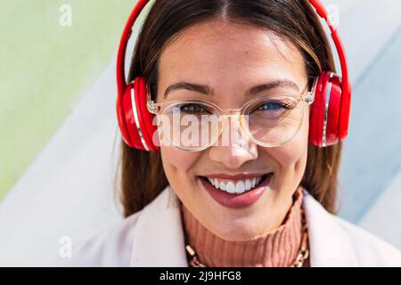 Felice giovane donna che indossa le cuffie Foto Stock