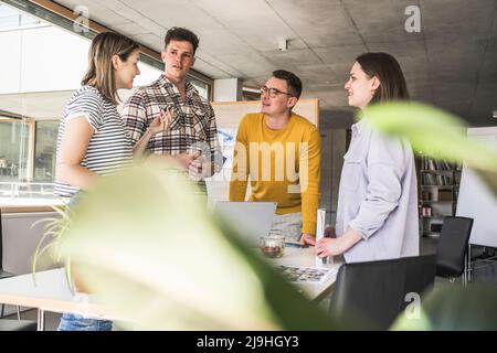 Giovani uomini d'affari che hanno una riunione in ufficio Foto Stock