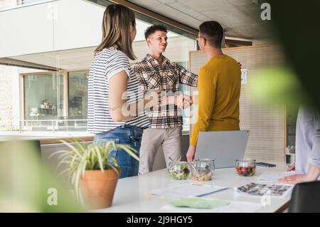 Due imprenditori stringono le mani in office Foto Stock