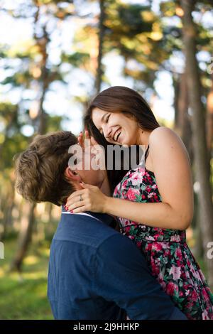 Giovane uomo lifting ragazza godendo nella foresta Foto Stock