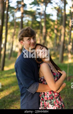 Donna con occhi chiusi testa appoggiata sulla spalla del ragazzo nella foresta Foto Stock