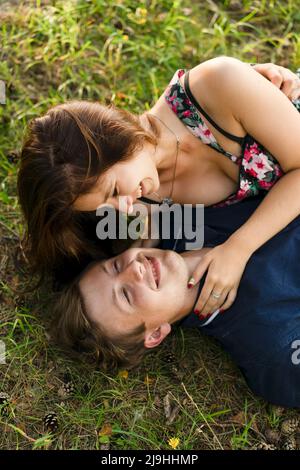 Felice coppia giovane sdraiato sull'erba Foto Stock