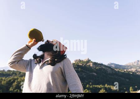 Uomo bearded che beve acqua in giorno di sole Foto Stock