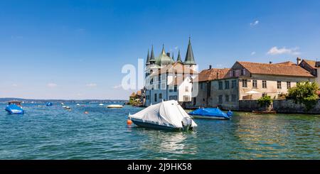 Svizzera, Thurgau, Steckborn, Shrink barche avvolte galleggiare vicino al lago di Costanza con case di città in background Foto Stock