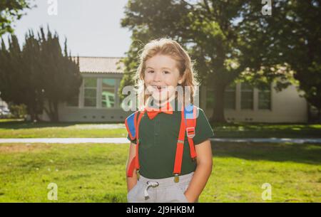 Bambino con zaini nel parco della scuola. Allievi con zaini all'aperto. Ragazzo nerd divertente. Foto Stock