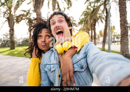 L'uomo felice gridando da ragazza puckering labbra al parco Foto Stock