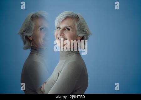 Esposizione multipla della donna anziana su sfondo blu Foto Stock