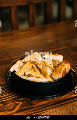 Chkmeruli o Shkmeruli è un piatto tradizionale georgiano di pollo in salsa all'aglio. Cucina georgiana. Chkmeruli o Shkmeruli è un georgiano tradizionale Foto Stock