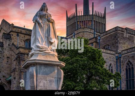 Cattedrale di Blackburn con statua della Regina Vittoria al tramonto. La statua è un monumento classificato di grado II situato a Blackburn, Lancashire, Regno Unito. Foto Stock