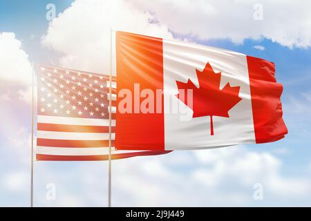 Cielo azzurro soleggiato e bandiere del canada e degli stati uniti Foto Stock