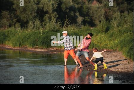 Famiglia di tre generazioni. Giorno dei padri. Giovane ragazzo con padre e nonno che si divertono insieme nel parco. Foto Stock