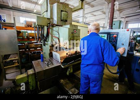 Ingegnere di fabbrica che lavora su tornio CNC. Foto Stock