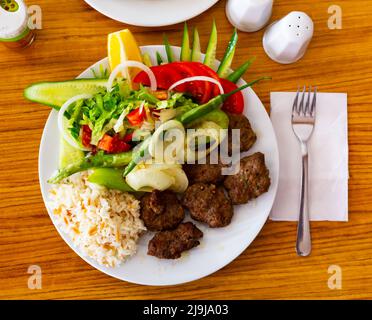 Kofte turco preparato su mangal con verdure e riso Foto Stock