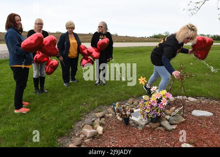 23 maggio 2022, città di Raymond, Wisconsin, Stati Uniti: La famiglia Peggy Lynn Johnson-SchroederÃs si radunò in 92nd Street nella città di Raymond, dove fu trovato il corpo di Peggy LynnÃs, per liberare 10 palloncini rossi, dopo che Linda LaRoche fu condannato a vita in prigione senza parole per l'omicidio di Johnson-Schroeder nel 1999 durante la sua udienza di condanna lunedì 23 maggio 2022. Il proprietario mantiene il sito come monumento a Peggy Lynn. Hanno scritto messaggi a Peggy sui palloncini prima di rilasciarli. (Credit Image: © Mark Hertzberg/ZUMA Press Wire) Foto Stock