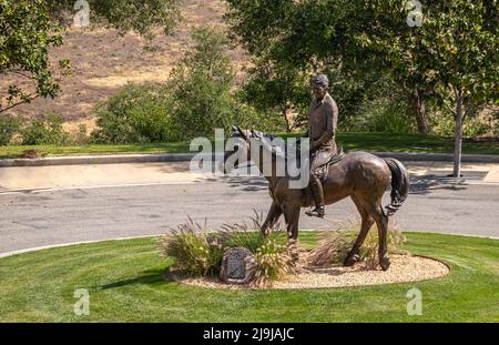 Simi Valley, California, USA - 27 aprile 2022: Biblioteca presidenziale Ronald Reagan. Lungo il sentiero bronzo statua equestre del presidente seduta su El Foto Stock