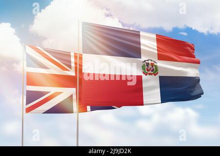 Cielo azzurro soleggiato e bandiere della repubblica dominicana e del regno unito Foto Stock