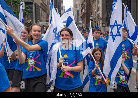 New York, US, 22/05/2022, i partecipanti che detengono bandiere israeliane marciano lungo la Fifth Avenue durante la Felebrate Israel Parade a New York City. Il JCRC-NY celebra la Parata d'Israele è la più grande espressione di solidarietà con lo Stato ebraico al mondo. Unisciti a noi e fai il tifo per più di 40.000 marchers, decine di favolosi carri allegorici, gruppi di marching e alcuni eccitanti artisti ebrei e israeliani! La sfilata procede fino alla Fifth Avenue da 57th Street a 74th Street, mostrando passione per lo Stato di Israele e amore per la comunità ebraica globale. Foto Stock