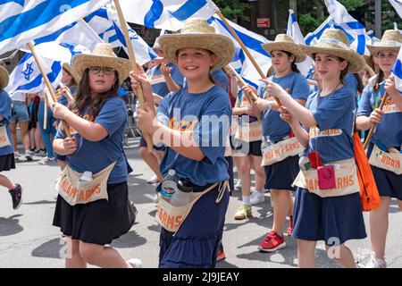 New York, US, 22/05/2022, i partecipanti che detengono bandiere israeliane marciano lungo la Fifth Avenue durante la Felebrate Israel Parade a New York City. Il JCRC-NY celebra la Parata d'Israele è la più grande espressione di solidarietà con lo Stato ebraico al mondo. Unisciti a noi e fai il tifo per più di 40.000 marchers, decine di favolosi carri allegorici, gruppi di marching e alcuni eccitanti artisti ebrei e israeliani! La sfilata procede fino alla Fifth Avenue da 57th Street a 74th Street, mostrando passione per lo Stato di Israele e amore per la comunità ebraica globale. Foto Stock