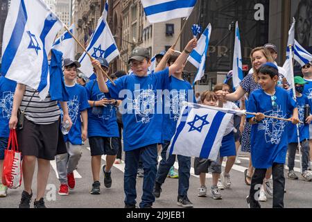 New York, US, 22/05/2022, i partecipanti che detengono bandiere israeliane marciano lungo la Fifth Avenue durante la Felebrate Israel Parade a New York City. Il JCRC-NY celebra la Parata d'Israele è la più grande espressione di solidarietà con lo Stato ebraico al mondo. Unisciti a noi e fai il tifo per più di 40.000 marchers, decine di favolosi carri allegorici, gruppi di marching e alcuni eccitanti artisti ebrei e israeliani! La sfilata procede fino alla Fifth Avenue da 57th Street a 74th Street, mostrando passione per lo Stato di Israele e amore per la comunità ebraica globale. Foto Stock