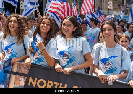 New York, US, 22/05/2022, i partecipanti che detengono bandiere israeliane marciano lungo la Fifth Avenue durante la Felebrate Israel Parade a New York City. Il JCRC-NY celebra la Parata d'Israele è la più grande espressione di solidarietà con lo Stato ebraico al mondo. Unisciti a noi e fai il tifo per più di 40.000 marchers, decine di favolosi carri allegorici, gruppi di marching e alcuni eccitanti artisti ebrei e israeliani! La sfilata procede fino alla Fifth Avenue da 57th Street a 74th Street, mostrando passione per lo Stato di Israele e amore per la comunità ebraica globale. Foto Stock