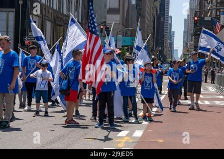 New York, US, 22/05/2022, i partecipanti che detengono bandiere israeliane marciano lungo la Fifth Avenue durante la Felebrate Israel Parade a New York City. Il JCRC-NY celebra la Parata d'Israele è la più grande espressione di solidarietà con lo Stato ebraico al mondo. Unisciti a noi e fai il tifo per più di 40.000 marchers, decine di favolosi carri allegorici, gruppi di marching e alcuni eccitanti artisti ebrei e israeliani! La sfilata procede fino alla Fifth Avenue da 57th Street a 74th Street, mostrando passione per lo Stato di Israele e amore per la comunità ebraica globale. Foto Stock