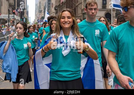 New York, US, 22/05/2022, i partecipanti che detengono bandiere israeliane marciano lungo la Fifth Avenue durante la Felebrate Israel Parade a New York City. Il JCRC-NY celebra la Parata d'Israele è la più grande espressione di solidarietà con lo Stato ebraico al mondo. Unisciti a noi e fai il tifo per più di 40.000 marchers, decine di favolosi carri allegorici, gruppi di marching e alcuni eccitanti artisti ebrei e israeliani! La sfilata procede fino alla Fifth Avenue da 57th Street a 74th Street, mostrando passione per lo Stato di Israele e amore per la comunità ebraica globale. Foto Stock