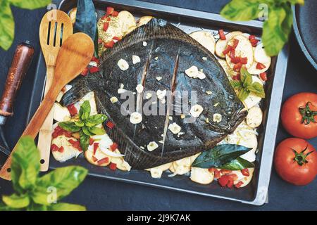 Pesce Turbot intero cotto in forno con patate, peperone ed erbe aromatiche. Pesce fresco. Foto Stock